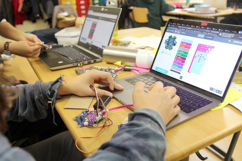Kinder arbeiten am Laptop mit Mikrocontroller und blockbasiertem Code.